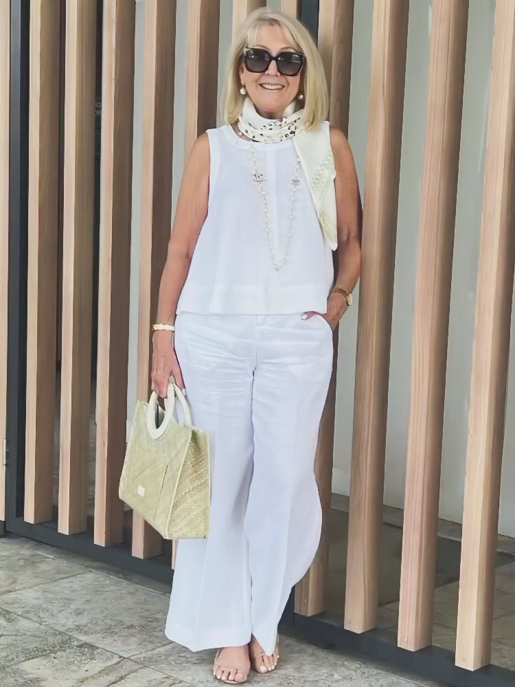 White sleeveless top and wide-leg pants with beaded trim and neck scarf