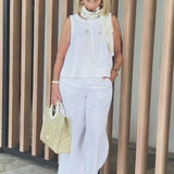 White sleeveless top and wide-leg pants with beaded trim and neck scarf