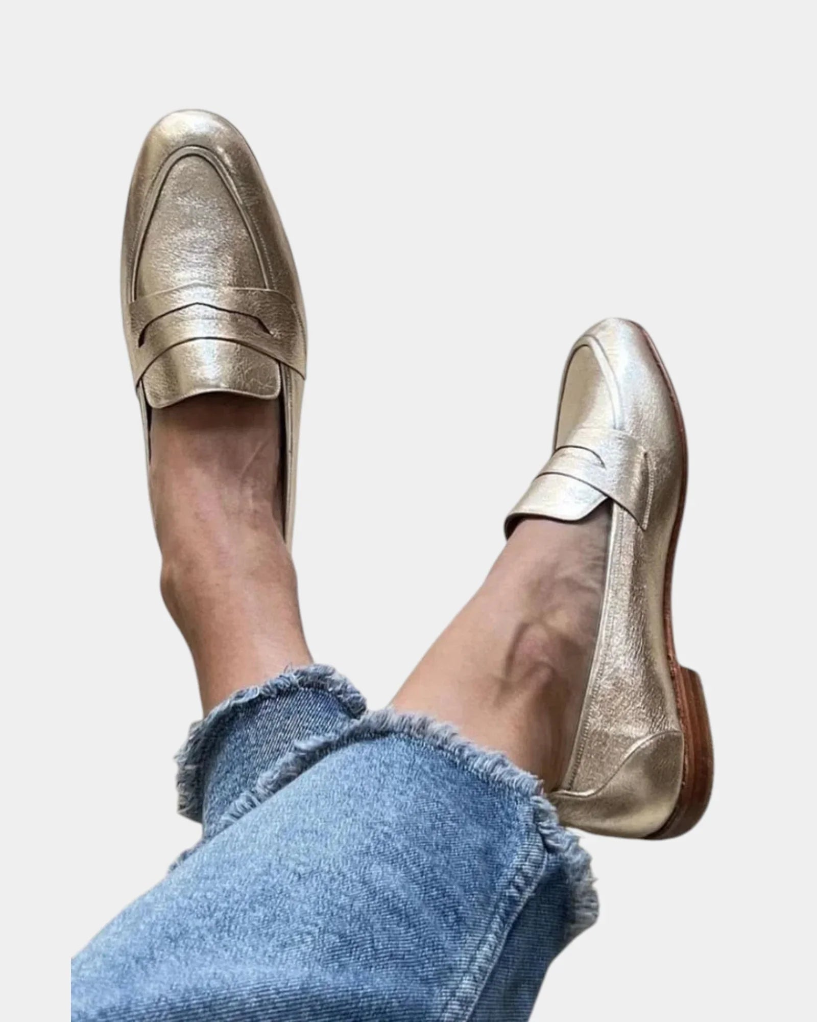 Shiny gold slip-on loafers with strap across the top