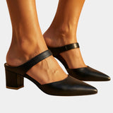 Black back-strap heels with pointed toe, buckle strap, and block heel