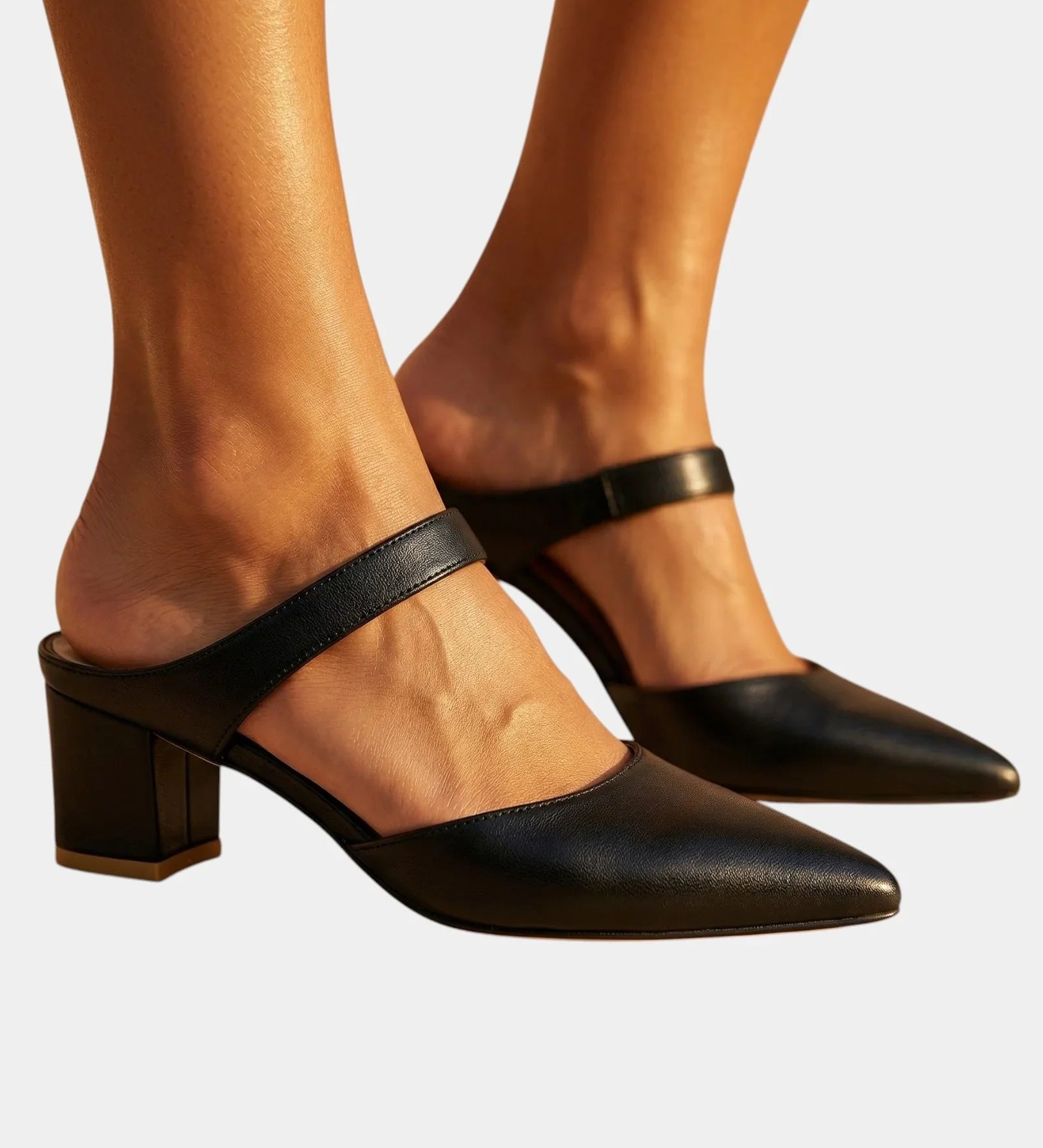 Black back-strap heels with pointed toe, buckle strap, and block heel