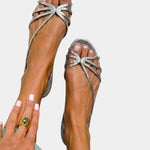 Silver strappy sandals with jeweled starburst bow and open toe.