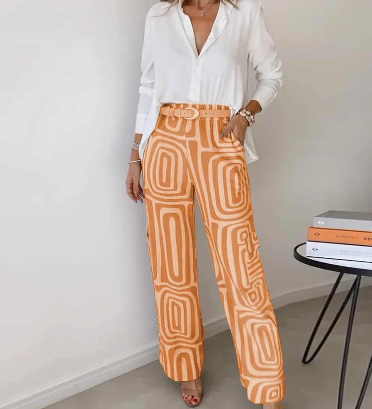 Two-piece outfit: white blouse with belt; wide-leg orange pants with cream abstract pattern