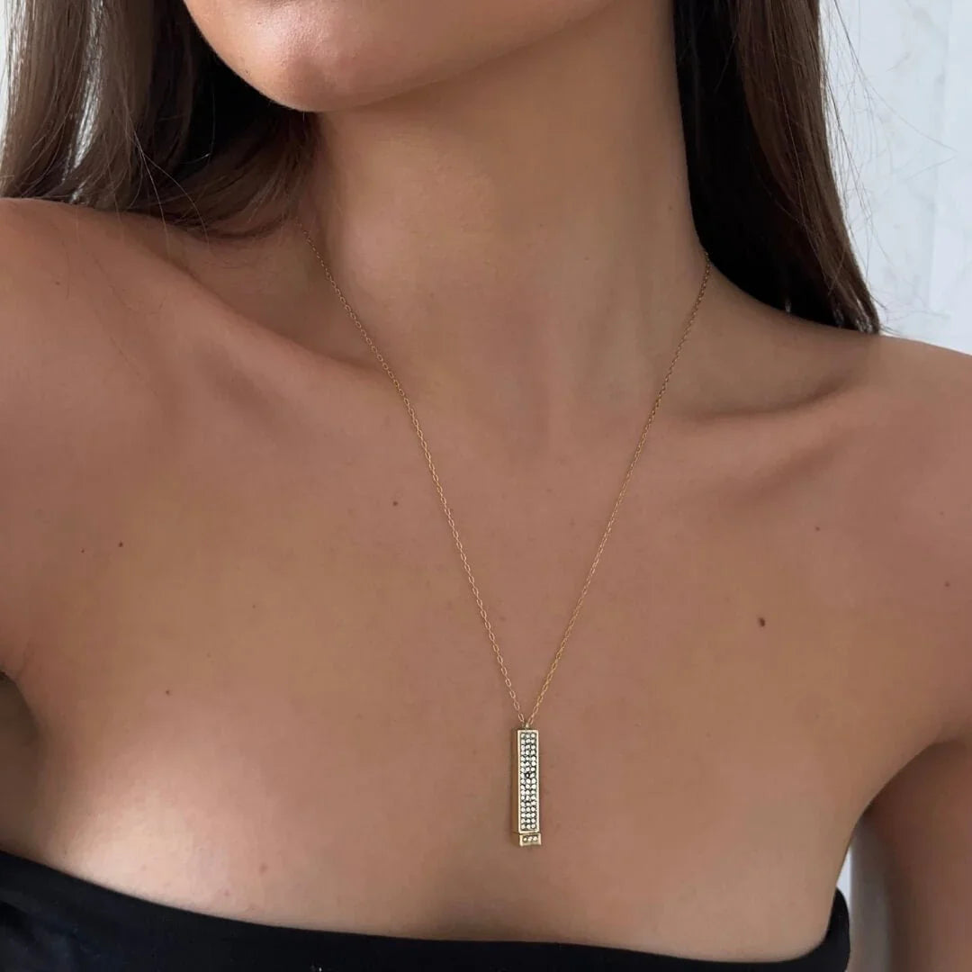 Gold-tone pendant necklace with rectangular clear-stone bar charm at center