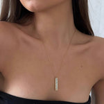 Gold-tone pendant necklace with rectangular clear-stone bar charm at center