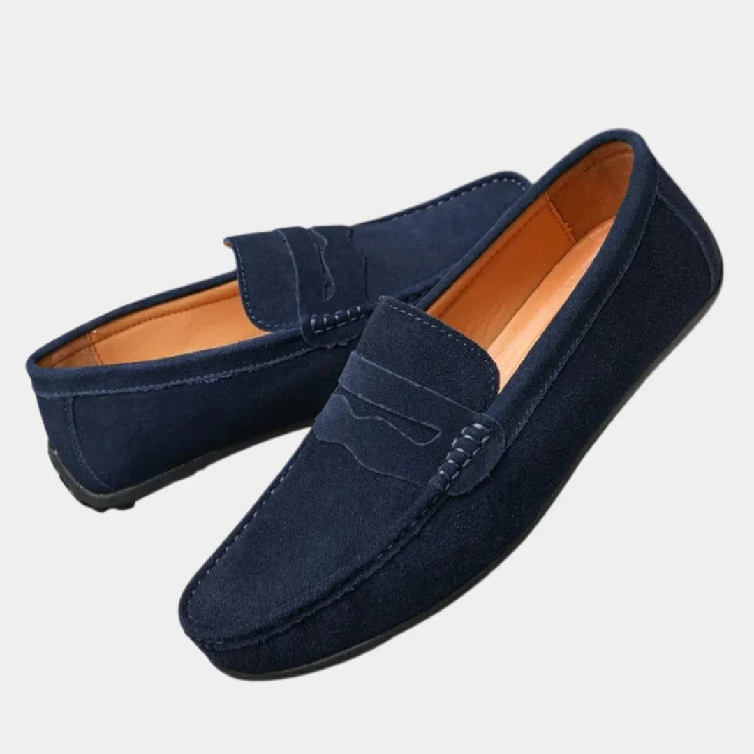 Navy blue suede loafers with slip-on strap and moc stitching detail