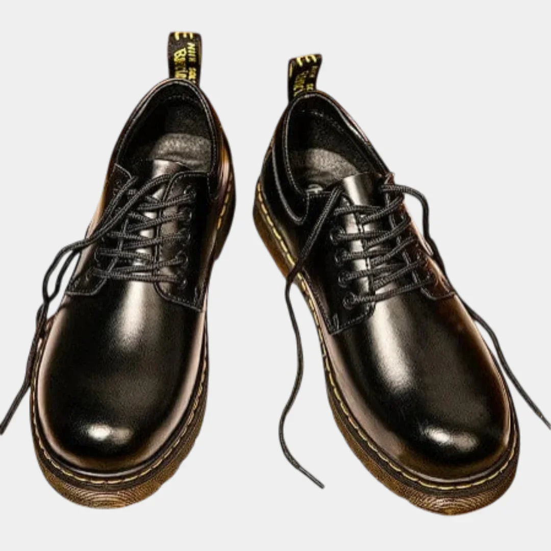 Black leather lace-up casual shoes with thick tan sole and yellow stitch detail