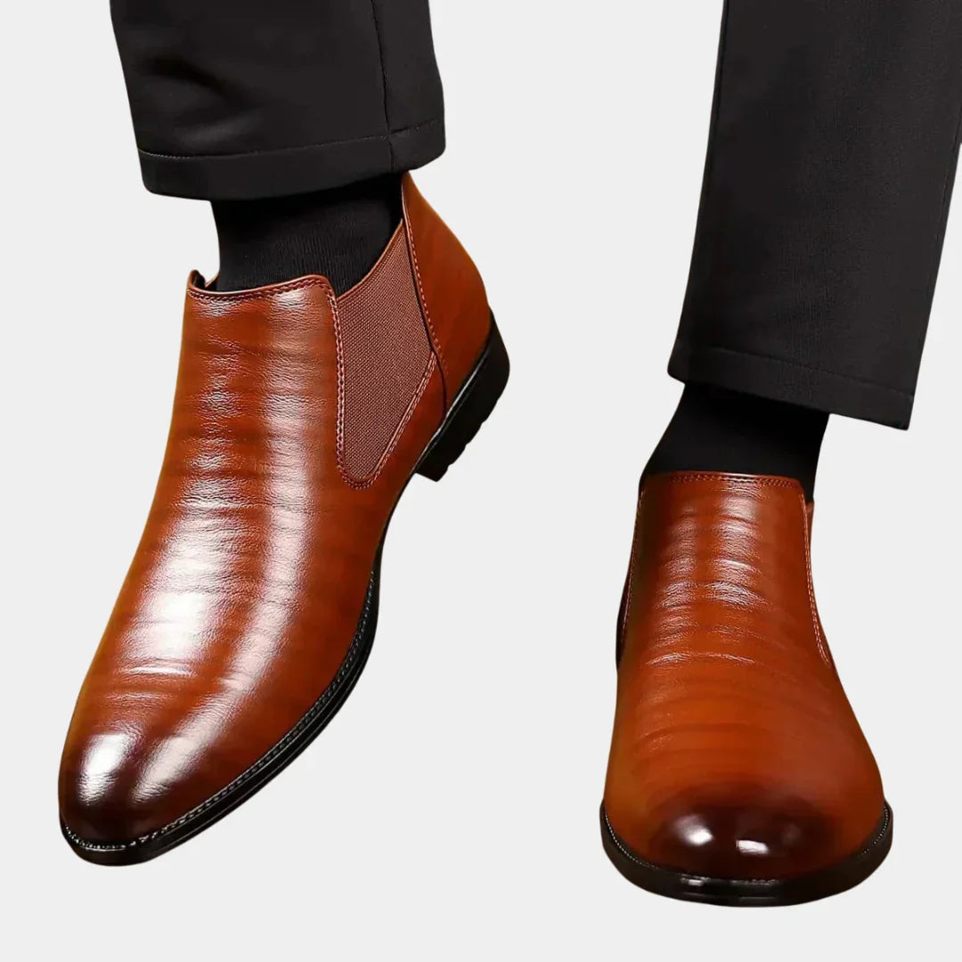 Brown leather ankle boots with elastic side panels and sleek almond toe.