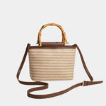 Beige knitted style bag with bamboo top handles and brown crossbody strap