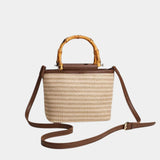 Beige knitted style bag with bamboo top handles and brown crossbody strap