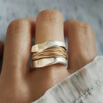 Ring on finger: polished silver band with gold wire line rows across the front