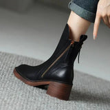 Black leather ankle boots with side zipper, tan sole edge, block heel