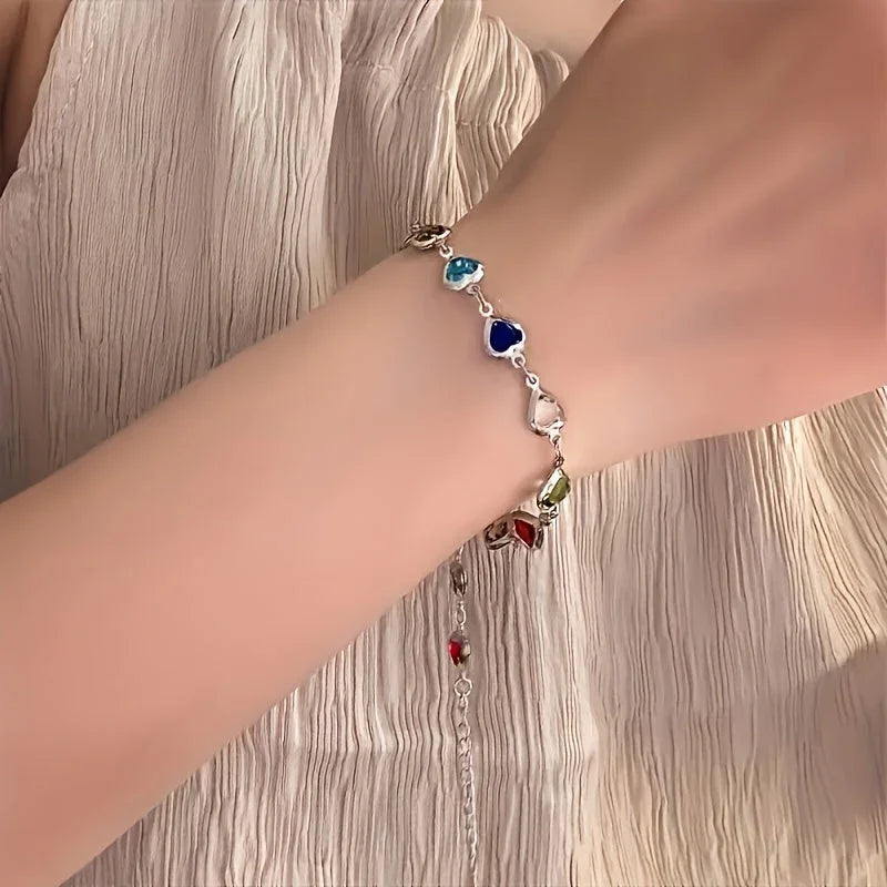 Silver-tone heart charm bracelet with blue and red gemstone hearts
