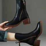 Pair of black ankle boots with side zipper and tassel, stacked block heel
