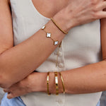 Gold charm bracelet with clover charms on a beaded chain