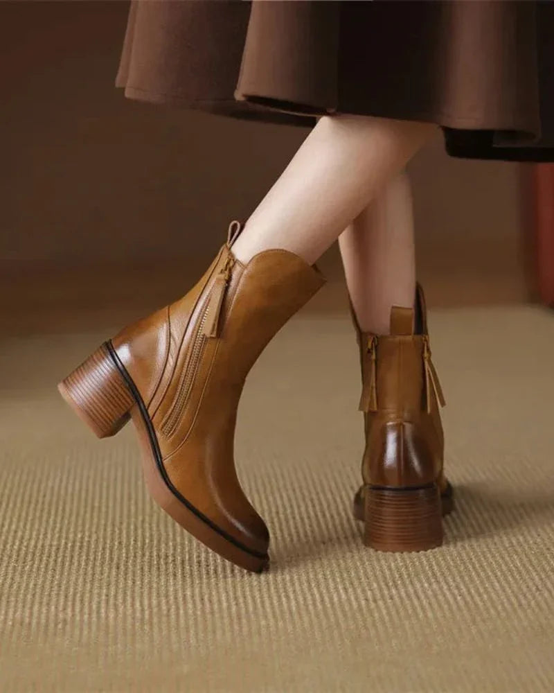 Brown leather ankle boots with block heel, side zip, and tassel details