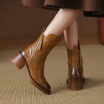 Brown leather ankle boots with block heel, side zip, and tassel details