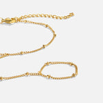 Close-up of gold chain hand bracelet with interlocking links and small bead details