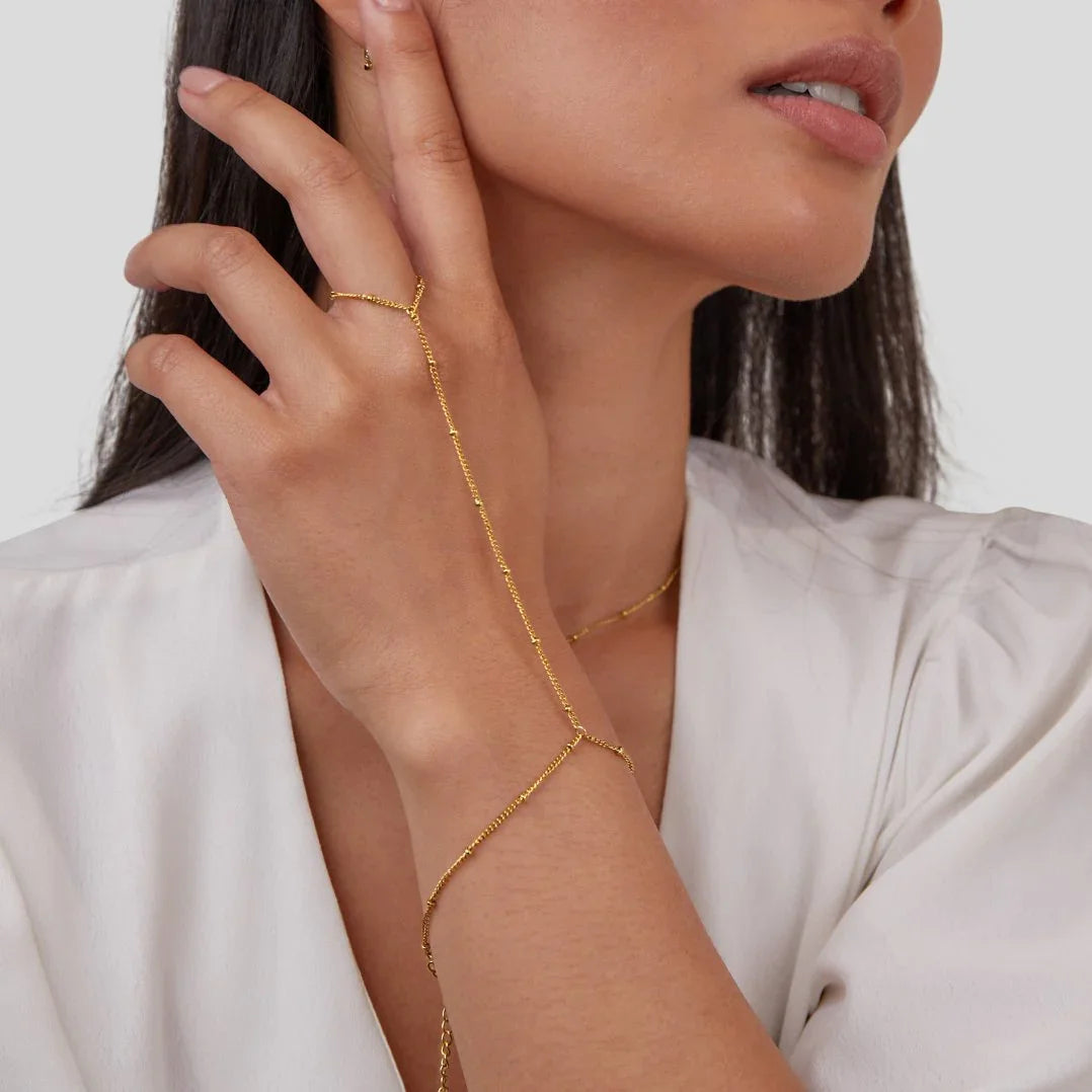 Gold chain hand bracelet worn on hand with slim linked design