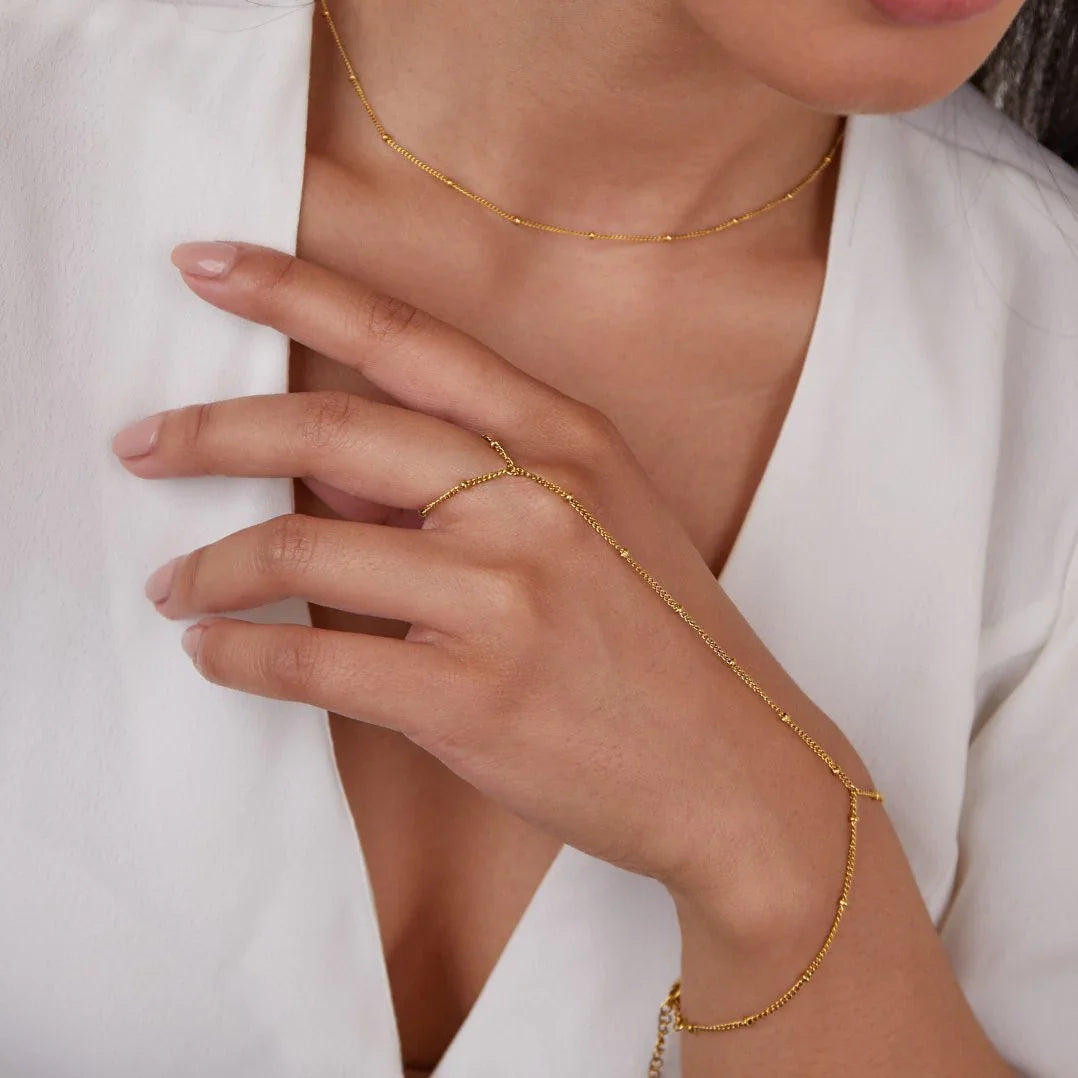 Gold chain hand bracelet with linked segments and small clasp