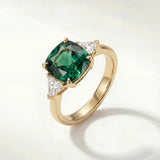 Gold ring with large green oval gemstone and small clear accents