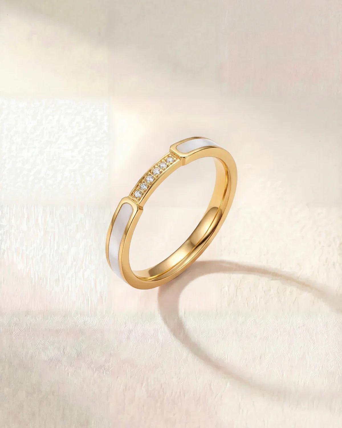 Gold band ring with a row of small clear stones on top