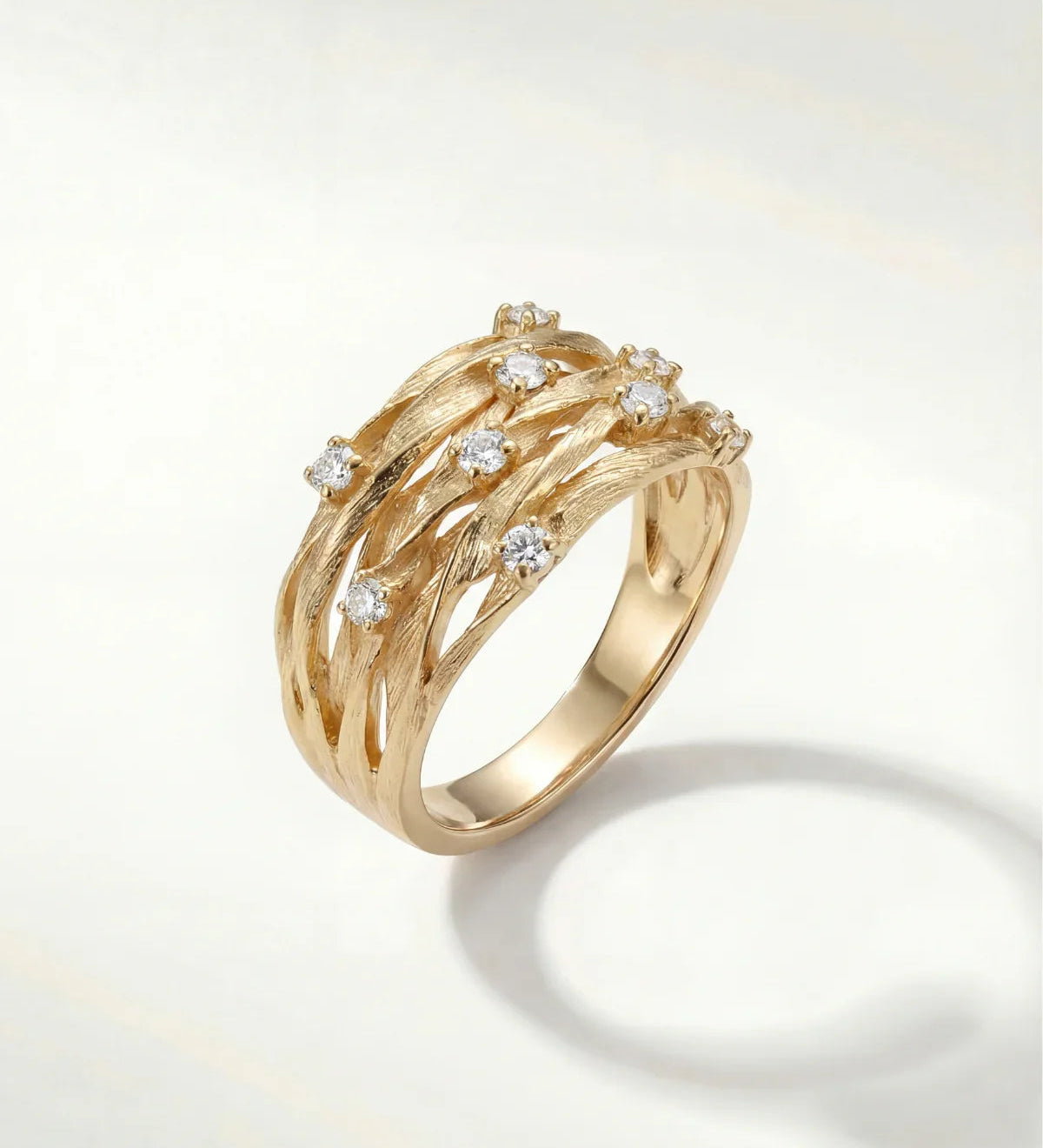 Gold-tone elegant ring with curved bands and small clear gemstone accents