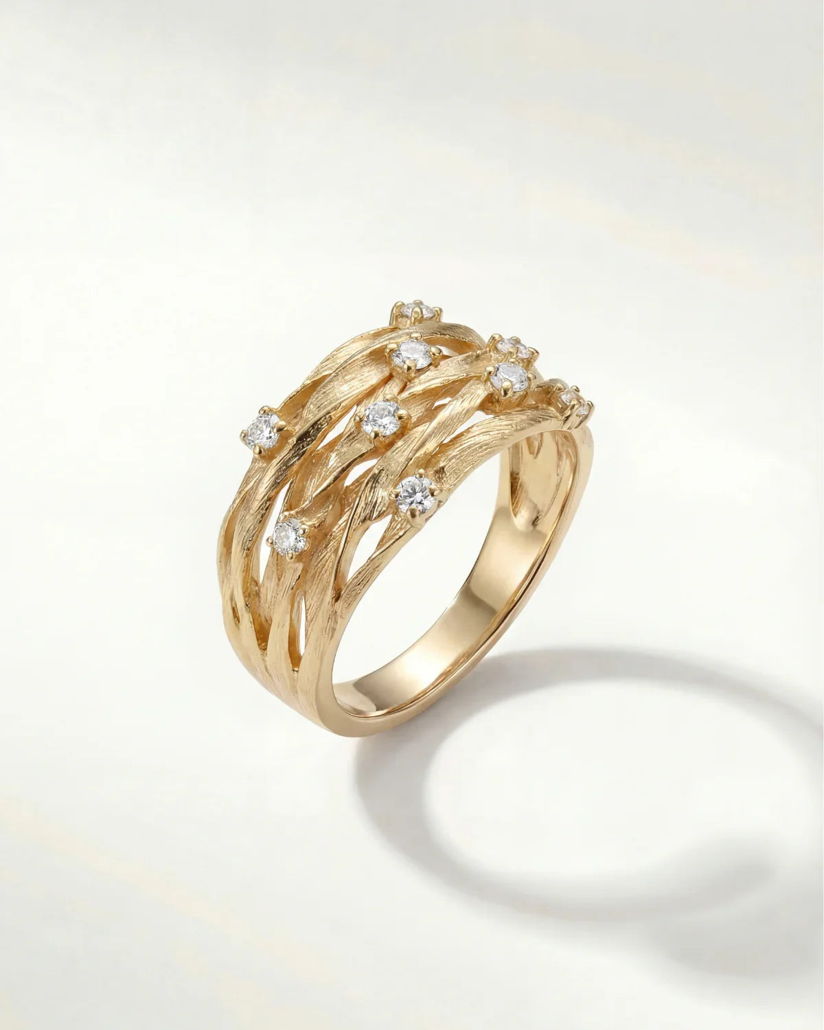 Gold-tone elegant ring with curved bands and small clear gemstone accents