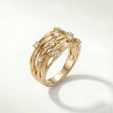 Gold-tone elegant ring with curved bands and small clear gemstone accents