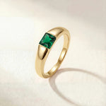 Gold-tone ring with a square green gemstone set on a tapered band
