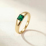 Gold-tone ring with a square green gemstone set on a tapered band