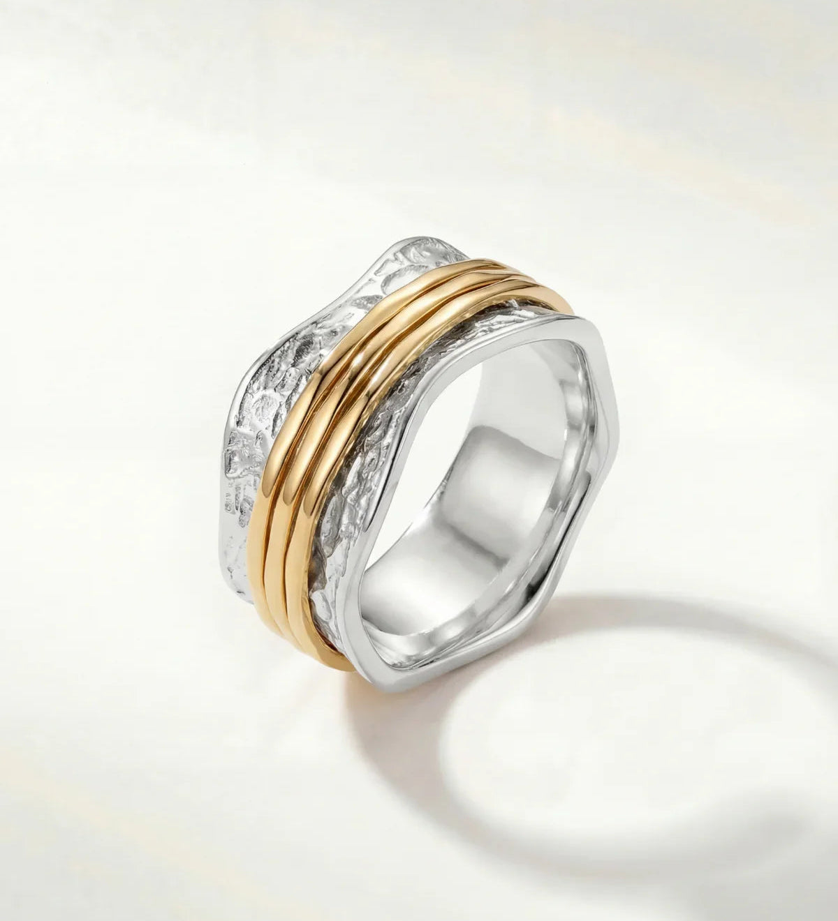 Stacked silver ring with textured band and two slim gold-tone bands