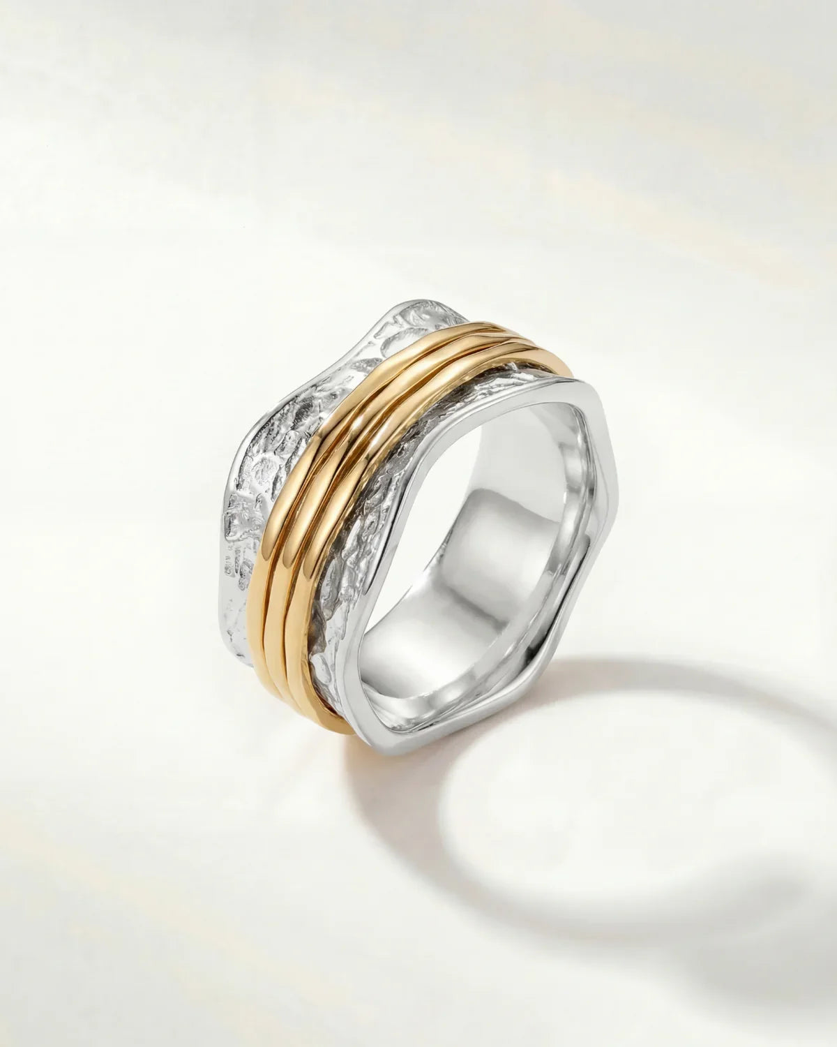 Stacked silver ring with textured band and two slim gold-tone bands