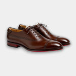 Brown lace-up brogue dress shoes with perforated detailing and cap toe