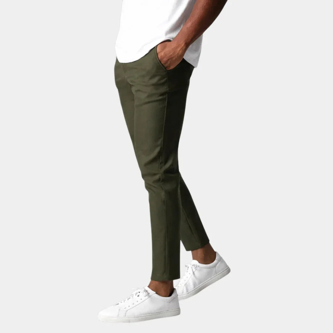 Olive green chino pants with front pockets and tapered ankle hem.