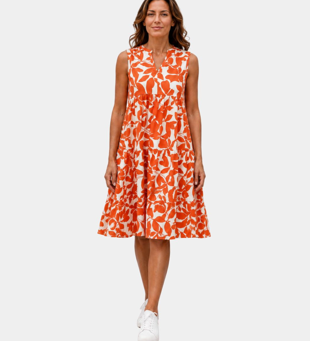 Orange sleeveless V-neck dress with bold leaf print and tiered ruffle hem