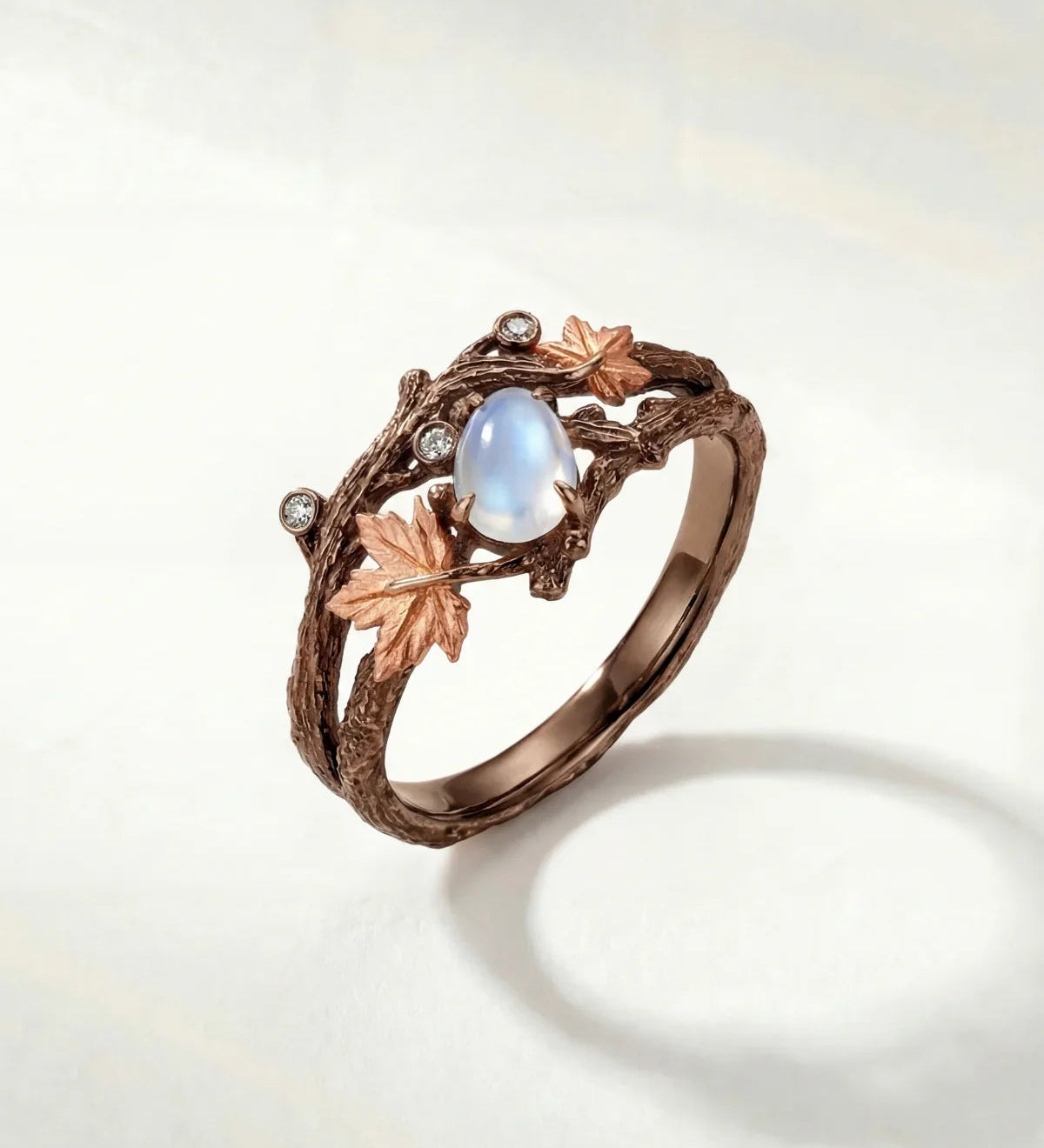Bronze branch-effect ring with oval opalescent blue center and clear sparkle stones