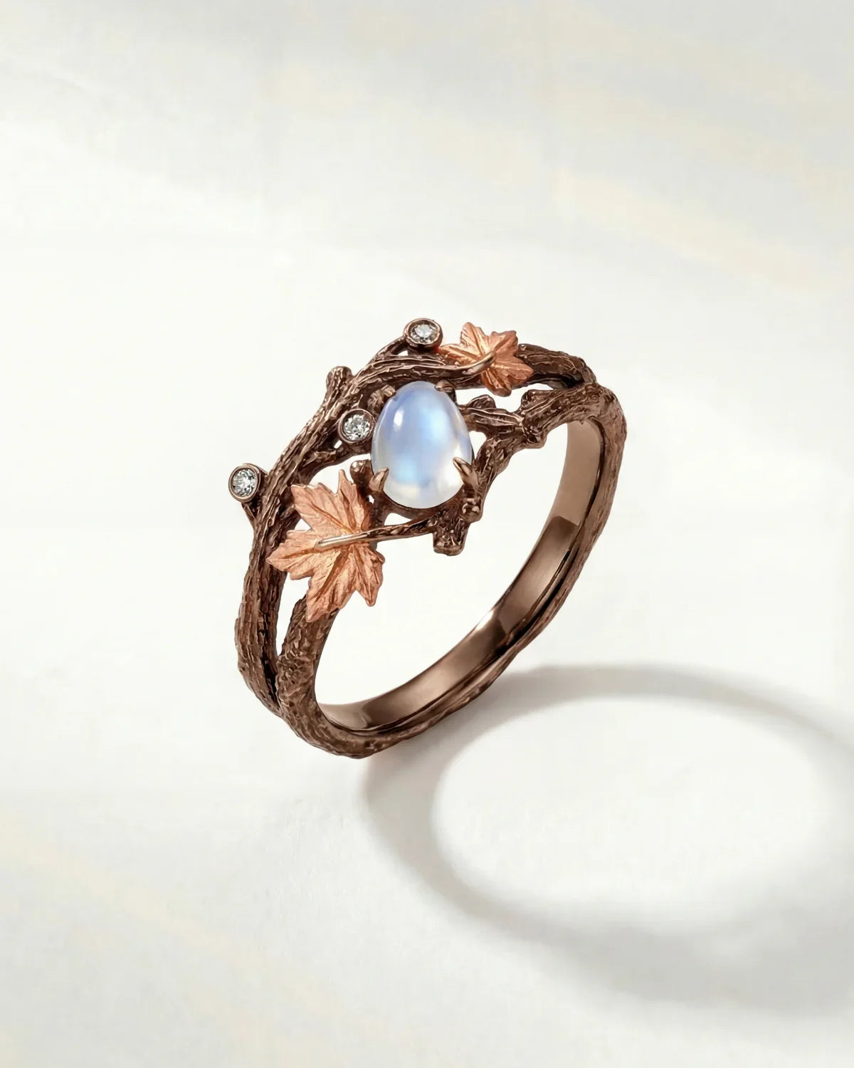 Bronze branch-effect ring with oval opalescent blue center and clear sparkle stones