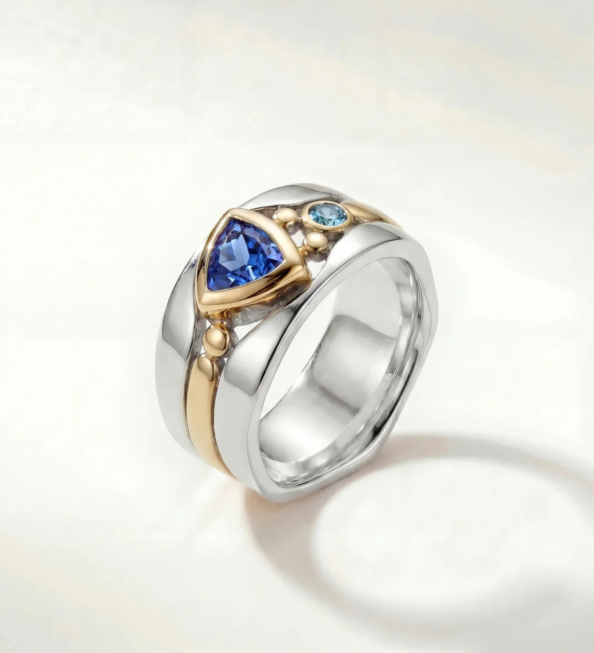 Silver statement ring with blue oval stone and gold-toned details on band