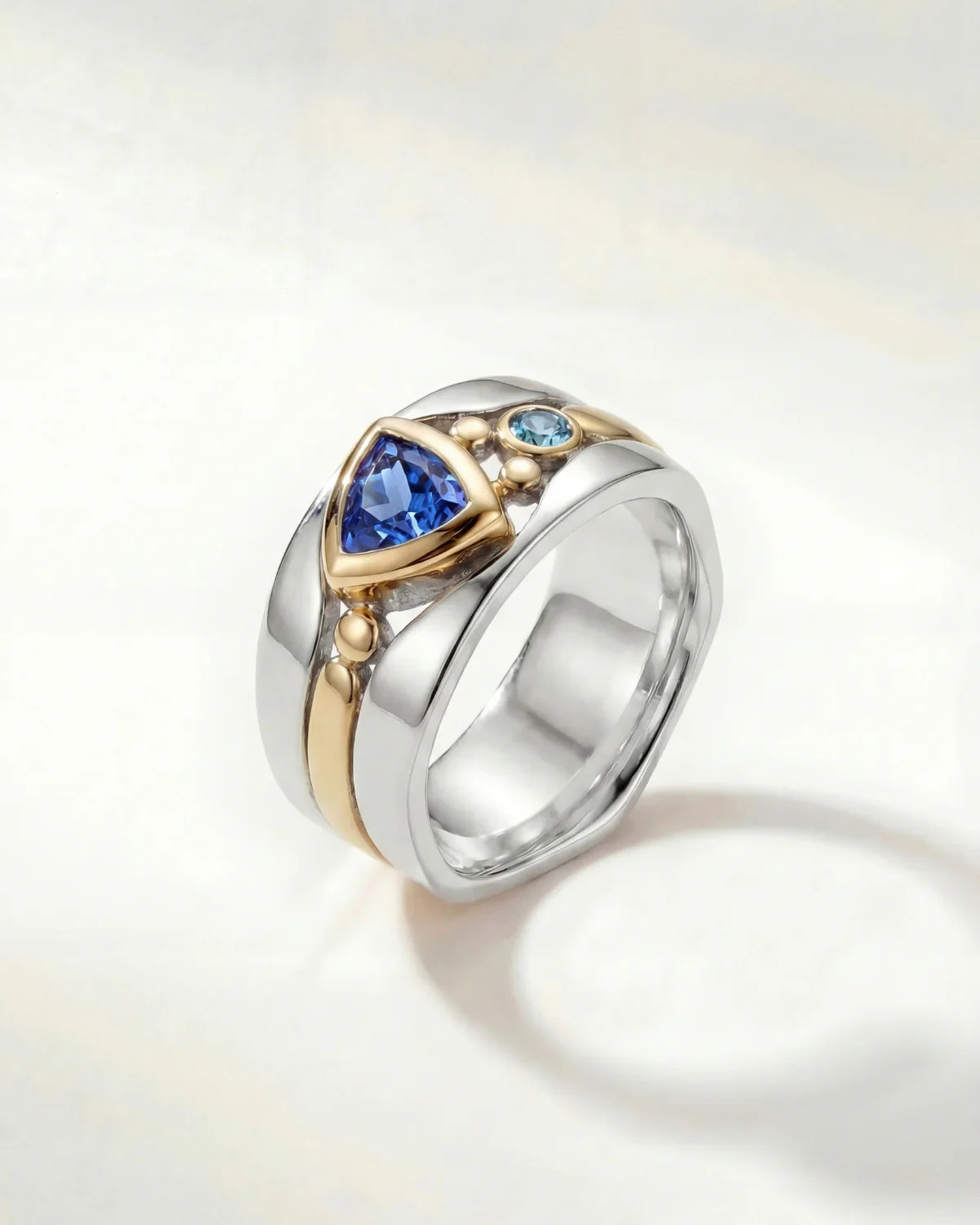 Silver statement ring with blue oval stone and gold-toned details on band