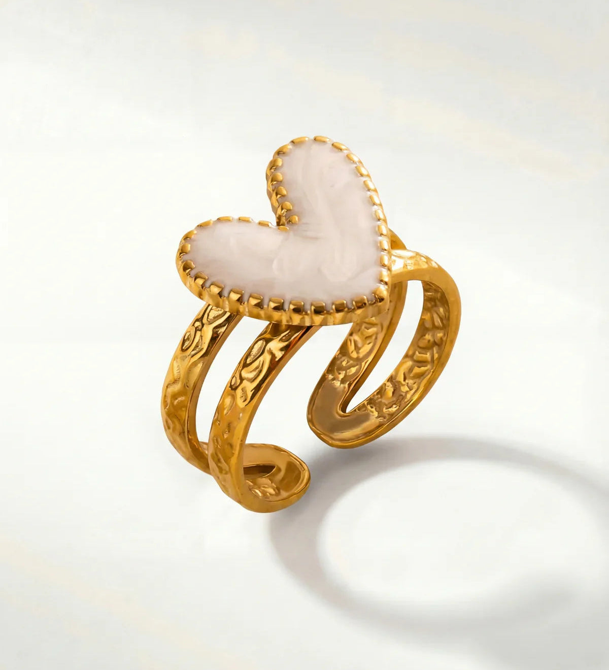 Gold heart ring with white enamel center and braided-style open band