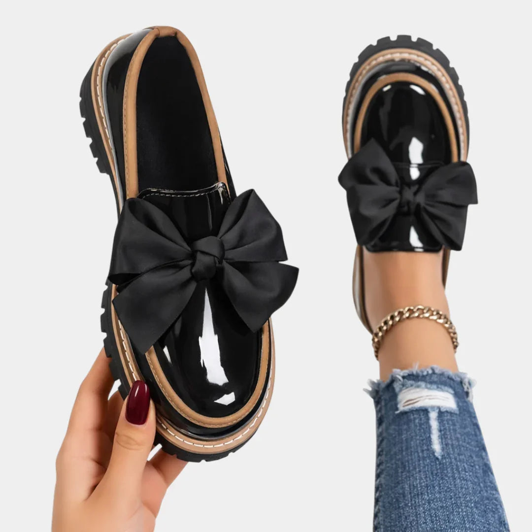 Black heeled loafers with chunky sole and large black bow detail