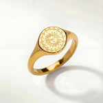 Gold-tone ring with oval sunburst engraving on the top and a smooth band
