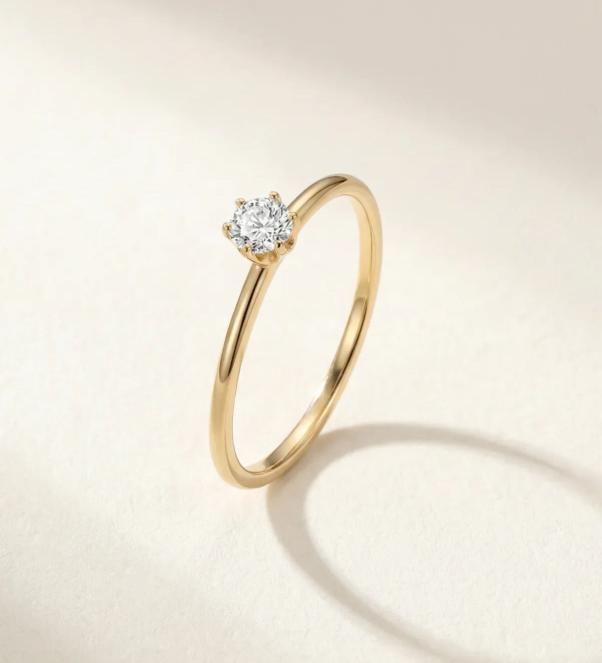 Gold-tone solitaire ring with round gemstone in a halo-like setting