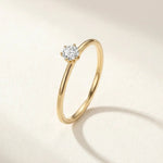 Gold-tone solitaire ring with round gemstone in a halo-like setting
