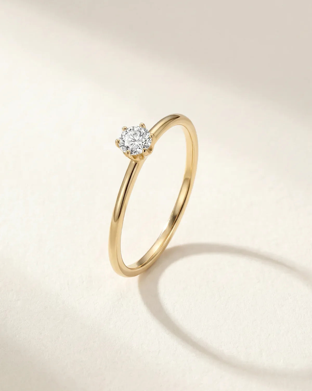 Gold-tone solitaire ring with round gemstone in a halo-like setting