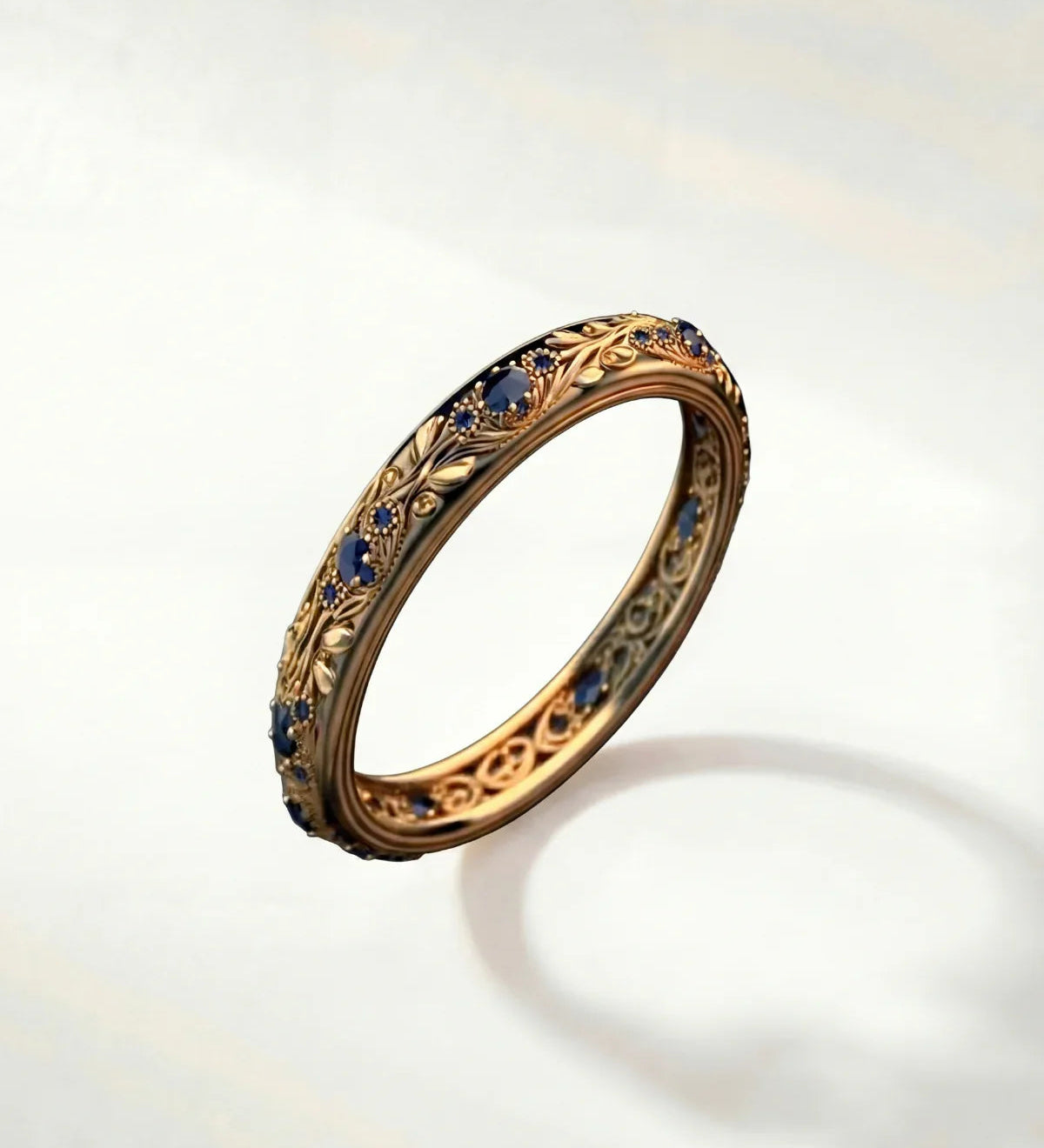 Gold ring with blue gemstones, ornate bezel and textured band