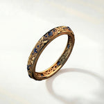 Gold ring with blue gemstones, ornate bezel and textured band