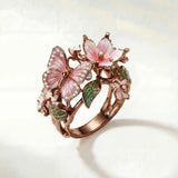 Bronze spring ring with pink flower, butterfly details and green leaf accents