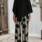 Back view: black asymmetrical top with batwing sleeves and wide-leg boho pants in dot print